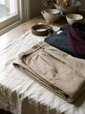 Waistband and double pleat detail of sand cotton trousers